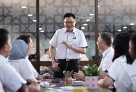 MISC team meeting with a leader presenting to colleagues in a corporate setting.