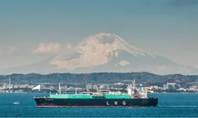 LNG tanker ship sailing near the coast with a mountain in the background.